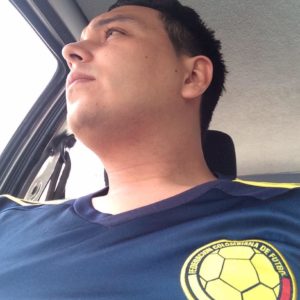 Hombre en auto mirando fuera de la ventana con camiseta de la selección Colombia