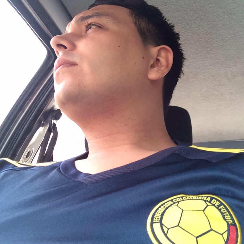 Hombre en auto mirando fuera de la ventana con camiseta de la selección Colombia