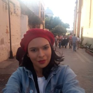 Mujer con gorro rojo paseando en una calle