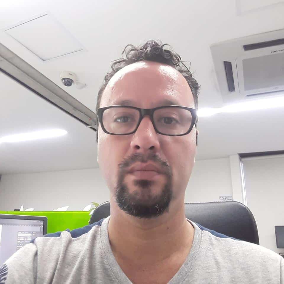 Hombre de mediana edad con gafas y camiseta gris en una oficina